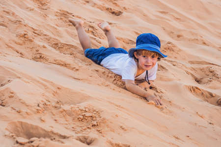 The boy in the red desert at dawn. Traveling with children concept.の写真素材