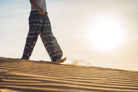 young woman in rad sandy desert at sunset or dawnの写真素材