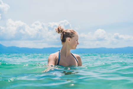 Close up portrait of beautiful young woman on the beach. Young caucasian female model Enjoys the sea.の写真素材