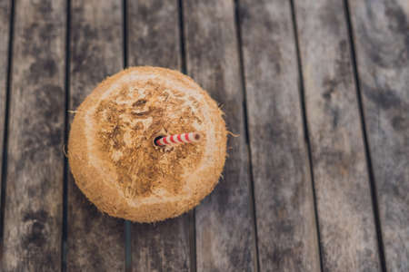 tropical landscape. fresh coconut with a straw on a sandy beach.の写真素材