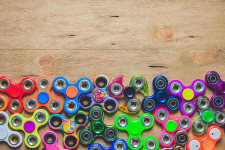 fidget spinners on wooden background with copy space, popular relaxing toy, generic design.の写真素材