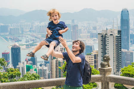 Father and son travelers at the peak of Victoria against the backdrop of Hong Kong. Traveling with children concept.の写真素材