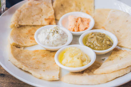 Pieces of pita bread and four kinds of Greek sauces. Greek food concept.の写真素材