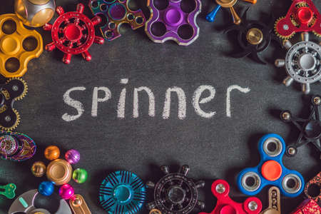 A lot of different spinners on a black background And the inscription spinner.の写真素材