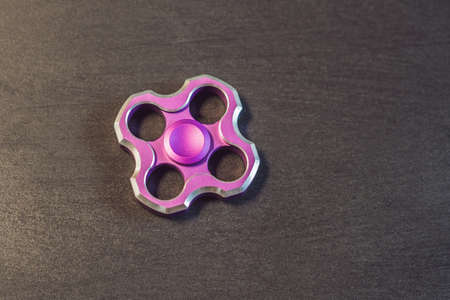 Famous fidget spinner stress relieving n a black wooden background.の写真素材