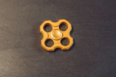 Famous fidget spinner stress relieving n a black wooden background.の写真素材
