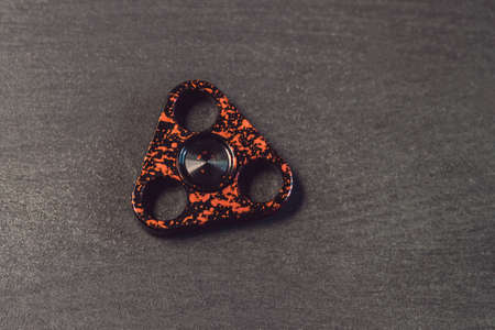 Famous fidget spinner stress relieving n a black wooden background.の写真素材