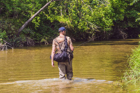Man fishing on a mountain river with a ultralight spinning using fishing wobblers. He got his hook...