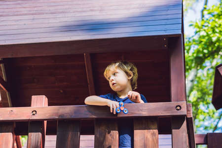 Boy playing with fidget spinner. Child spinning spinner on the playground. Blurred background.の写真素材