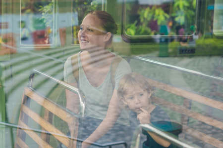 Mom and son are going to go on an old tram. Traveling with children in Hong Kong concept.の写真素材