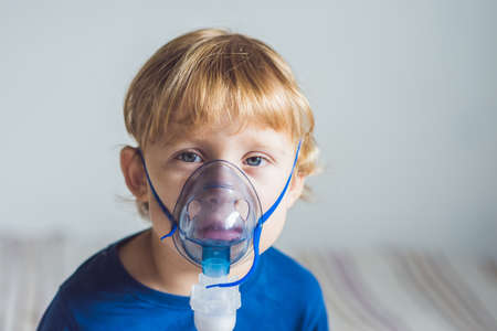 Boy making inhalation with a nebulizer at home.の写真素材