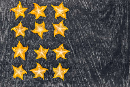 Star fruits on wooden table. Thai fruit : Star fruit is popular in asia, sweet taste fruits. Star fruits sliced on wood background. Selective focus.の写真素材