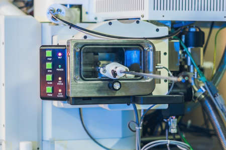Scientist in a laboratory works with an electron microscope gateway. Putting a sample into a chamber.の写真素材