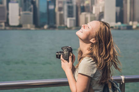 Young woman taking photos of victoria harbor in Hong Kong, China.の写真素材