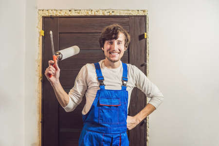 Young handyman installing door with an mounting foam in a room.の写真素材