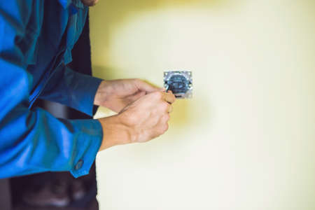 A young electrician installing an electrical switch in a new house.の写真素材