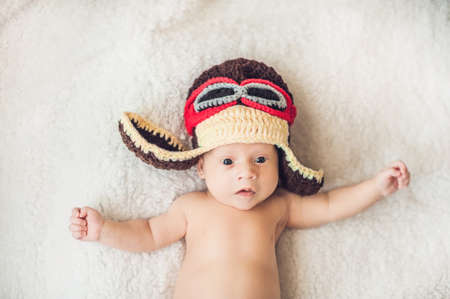 cute smiling baby in the cap of the pilot is flying on a white background.の写真素材
