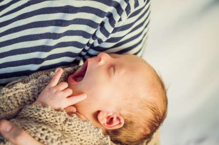 Young father holding his newborn baby son in his arms.の写真素材