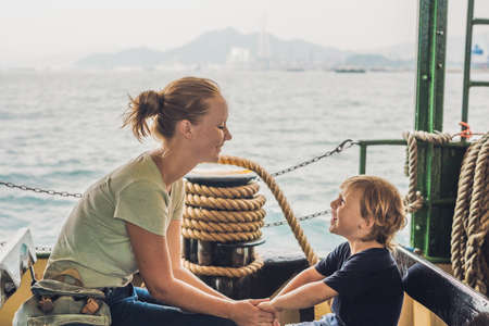 Mom and son go by ferry in Hong Kong.の写真素材