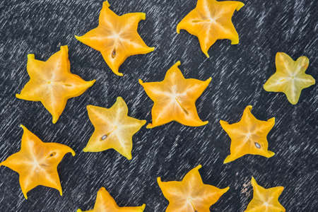 Star fruits on wooden table. Thai fruit : Star fruit is popular in asia, sweet taste fruits. Star fruits sliced on wood background. Selective focus.の写真素材