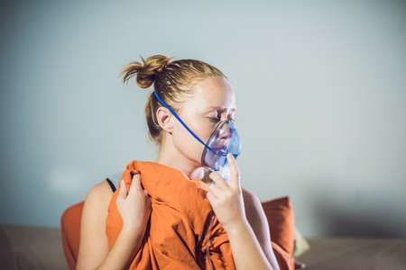 Woman with flu or cold symptoms making inhalation with nebulizer - medical inhalation therapy.の写真素材