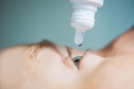 Closeup of eyedropper putting liquid into open eye.の写真素材
