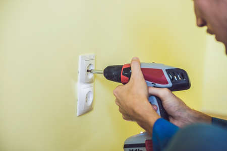 Electrician Installing Socket In New House. Electrician in the house