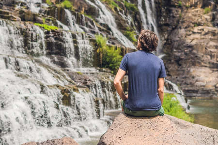 Man hiker, tourist on the background of Amazing Pongour Waterfall is famous and most beautiful of fall in Vietnam. Not far from Dalat city estimate 45 Km. Dalat, Vietnam.の写真素材