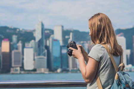 Young woman taking photos of victoria harbor in Hong Kong, China.の写真素材