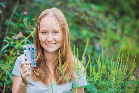Young man holds in her hand allergy tablets because of an allergy to ragweed.の写真素材