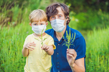 Father and son in a medical mask because of an allergy to ragweed.の写真素材