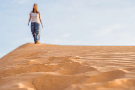 young woman in rad sandy desert at sunset or dawnの写真素材