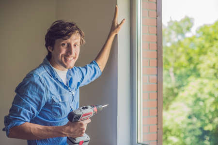 Man in a blue shirt does window installation.