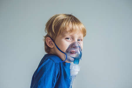 Boy making inhalation with a nebulizer at home.の写真素材