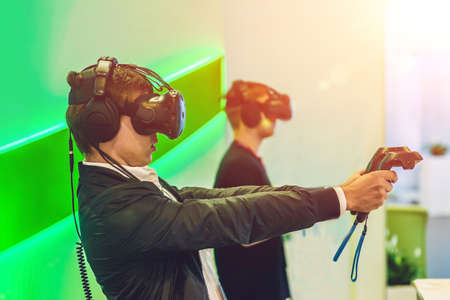 Young man playing video games virtual reality glasses. Cheerful man having fun with new trends technology - Gaming concept.の写真素材