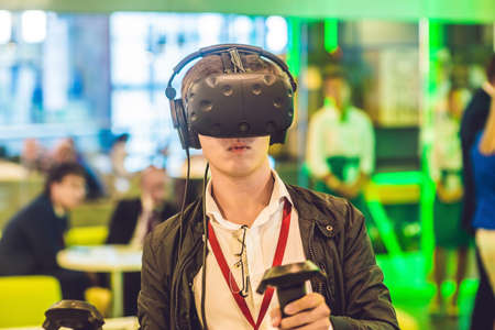 Young man playing video games virtual reality glasses. Cheerful man having fun with new trends...