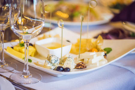 Honey and cheeses on a white plate, food.の写真素材