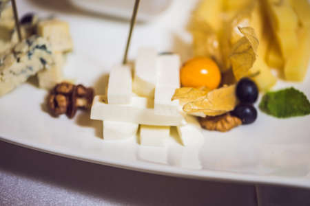 Honey and cheeses on a white plate, food.の写真素材