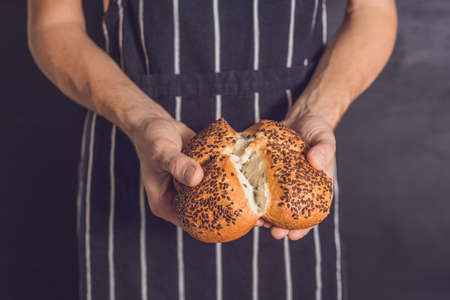 Bread with flax seeds in the hands of a baker.の写真素材
