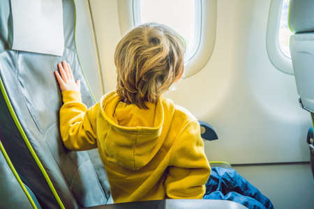 little boy in the plane looking out the window.の写真素材