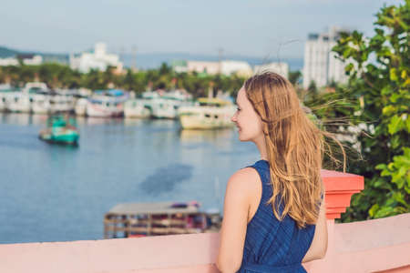 Beautiful young cheerful woman against the background of the sea and Vietnamese boats.の写真素材
