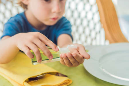 Boy using wash hand sanitizer gel in the cafe.の写真素材
