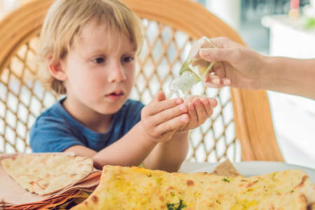 Boy using wash hand sanitizer gel in the cafe.の写真素材