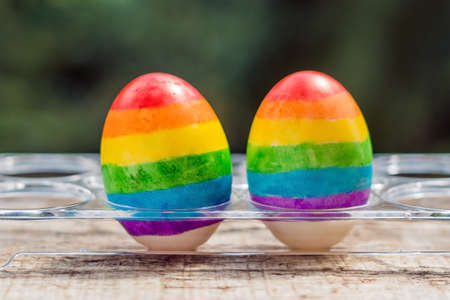 Two eggs are colored in the colors of the rainbow as a flag of gays and lesbians as well as Easter eggs. Homosexual concept.の写真素材
