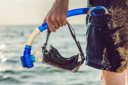 A man with a mask and snorkel is going to dive into the sea.の写真素材