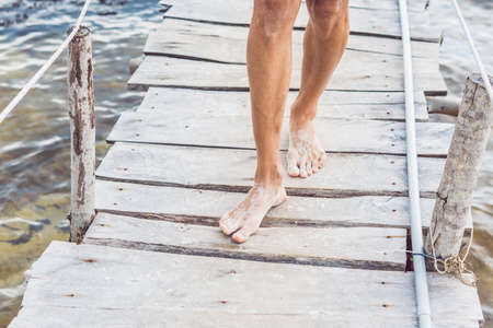 Legs on the old pier on the background of the sea.の写真素材