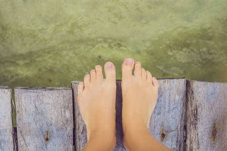 Legs on the old pier on the background of the sea.の写真素材