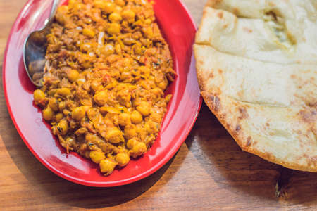 Indian Food or Indian Curry in a copper brass serving bowl with nan bread or roti.の写真素材