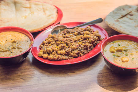 Indian Food or Indian Curry in a copper brass serving bowl with nan bread or roti.の写真素材