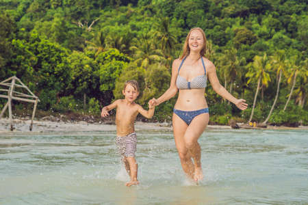 Young loving mother and her little son playing on the beach.